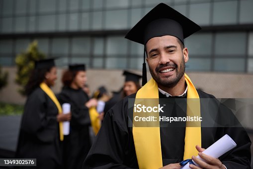 istock Happy graduate student holding his diploma on graduation day 1349302576