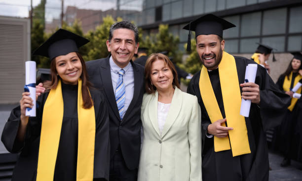 Graduate students smiling with their parents on their graduation day Portrait of happy Latin American graduate students smiling with their parents on their graduation day while looking at the camera - education concepts colombia photos stock pictures, royalty-free photos & images