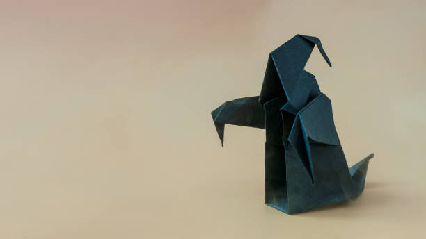 istock A dark paper ghost on a colored background is a place for text. 1349305786