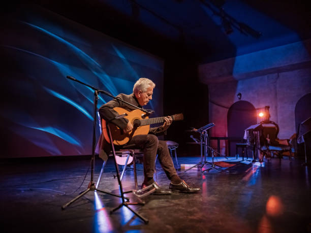 mature male guitarist on the stage with classic guitar - men artist guitarist guitar imagens e fotografias de stock