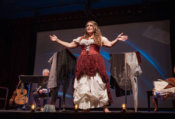 Mature female Performer on the stage Mature woman Performer singing on the stage. She is dressed in period costume. Stage interior of Theatre during performance at night. stage actress stock pictures, royalty-free photos & images