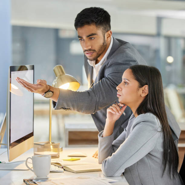 aufnahme einer jungen geschäftsfrau mit einem computer in einem modernen büro - trainee suit men business person stock-fotos und bilder