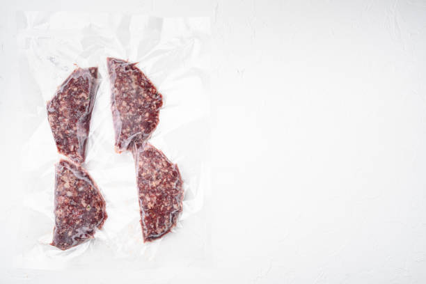 istock Beef veal cutlets in vacuum plastic pack, on white stone table background, top view flat lay, with copy space for text 1349312769