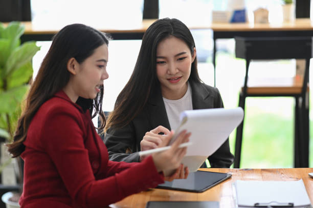 istock Two successful businesswoman discussing and checking reports together. 1349314727