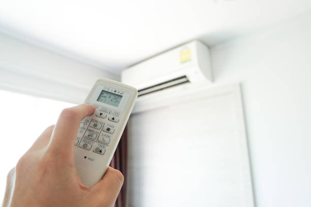 istock Man's hand using remote control open The air conditioner is cooled to 25 degrees Celsius in his bedroom. Health concepts and energy savings 1349316558