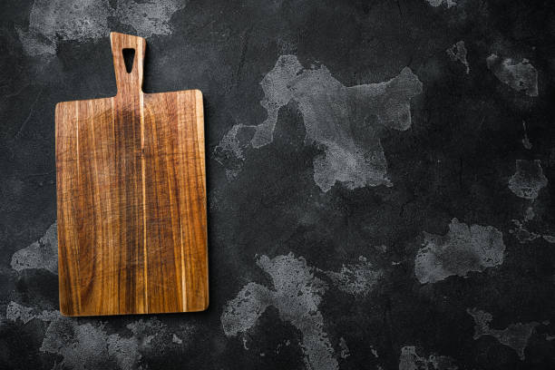 istock Pine wooden cutting board, on black dark stone table background, top view flat lay , with copy space for text or your product 1349317318