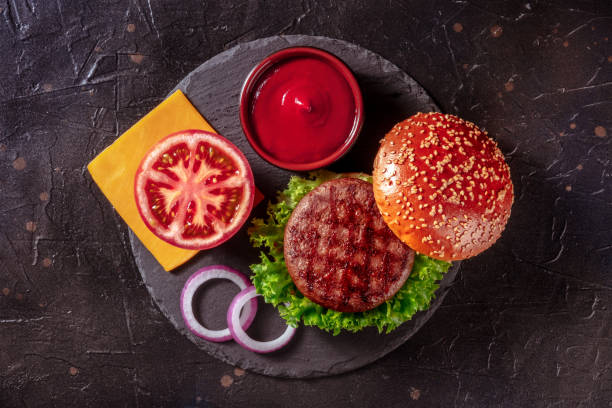 istock Burger ingredients, overhead shot on a black background. Hamburger beef 1349318615