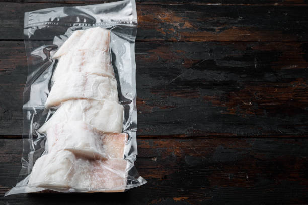 istock Haddock fish skinless in vacuum pack, on old wooden table, top view with copy space for text 1349319633