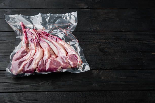 ラムリブ真空は、テキストのためのコピースペースとスペースで、黒い木製のテーブルの背景に、スーヴィード調理の準備ができて密封 - rack of lamb chop raw meat ストックフォトと画像