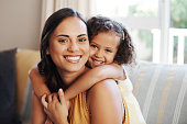 istock Shot of an adorable young girl hugging her mother in the living room at home 1349321675