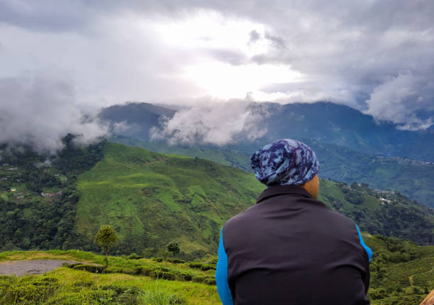 istock man sitting at mountain top with dramatic sky at morning 1349324218