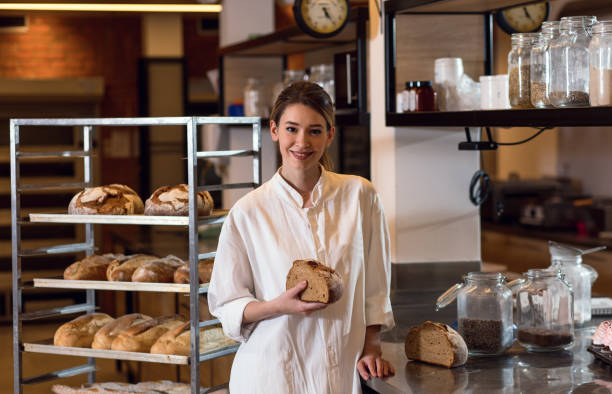 istock Portrait of young female baker standing at bakery. 1349324230
