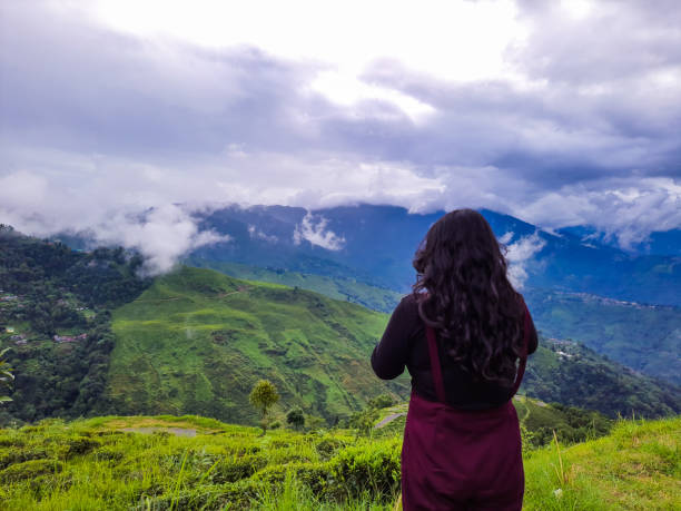 istock girl standing at mountain top with dramatic sky at morning 1349326337