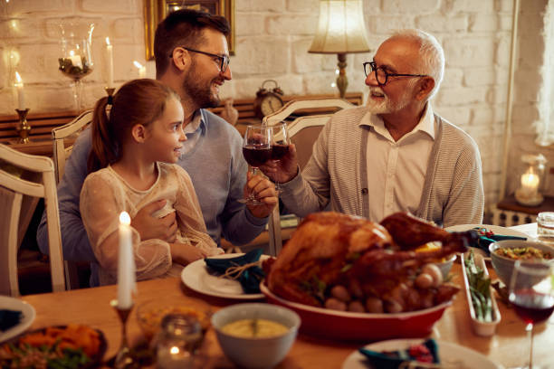 istock Happy senior man and his son toasting during Thanksgiving meal at dining table. 1349328705
