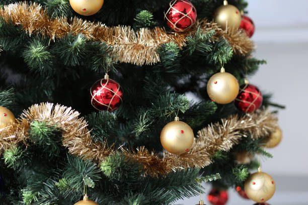 Artificial Christmas tree decorated with red-gold balls and tinsel stock photo
