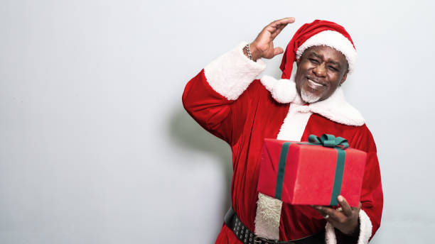 istock Santa Claus holding christmas gift on grey background 1349330320
