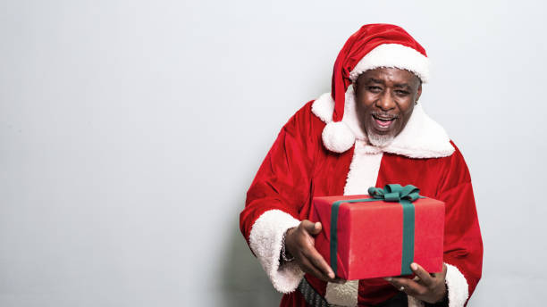 istock Santa Claus holding christmas gift on grey background 1349330323