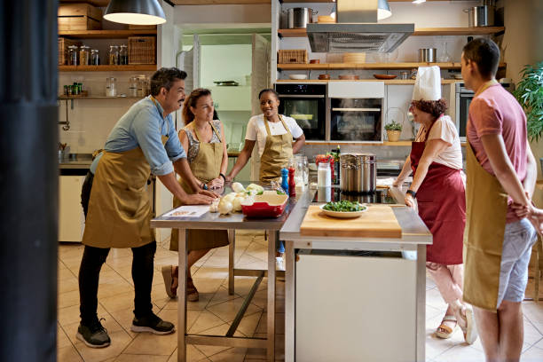 istock Senior Chef Teaching Adult Students in Cooking Class 1349332383