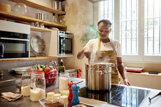 istock Adult Student Stirring Steaming Pot in Cooking Class 1349332384