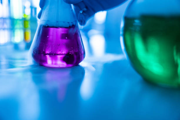 istock Close up of taking smoking laboratory flask with purple liquid. 1349332618