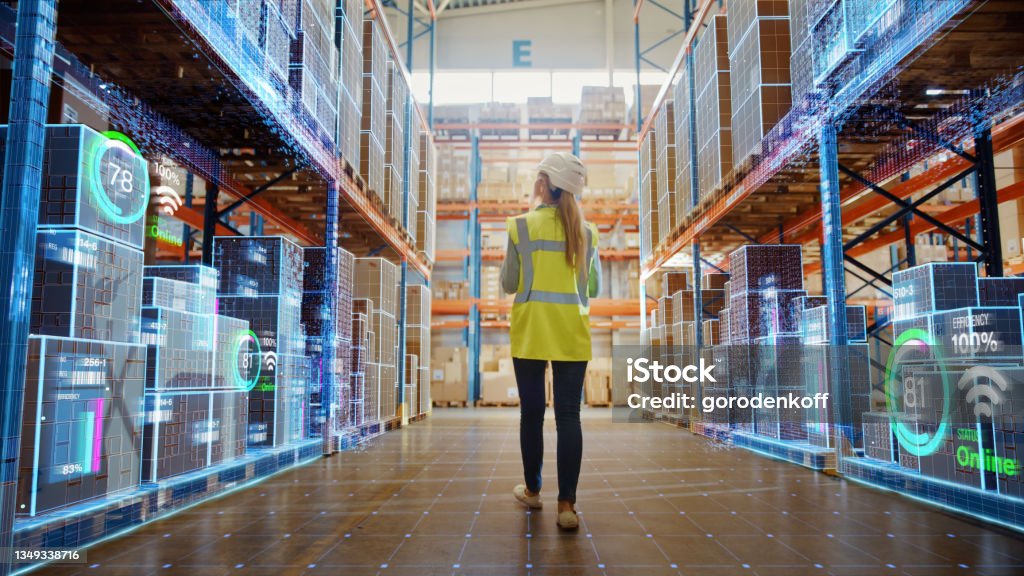 Futuristic Technology Retail Warehouse: Worker Doing Inventory Walks when Digitalization Process Analyzes Goods, Cardboard Boxes, Products with Delivery Infographics in Logistics, Distribution Center Freight Transportation Stock Photo