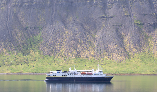 Dynjandi, Iceland on august 6, 2021: National Geographic explorer floating in the fjord near Dynjandi