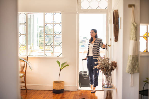 young woman with a suitcase arriving at her vacation rental accommodation - returning imagens e fotografias de stock