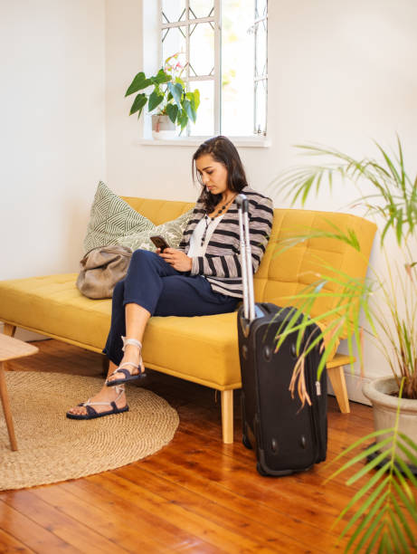 istock Young woman with a suitcase checking her phone in her rental accommodation 1349341825
