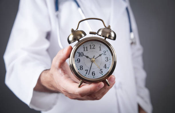 istock Caucasian doctor holding alarm clock. 1349342741