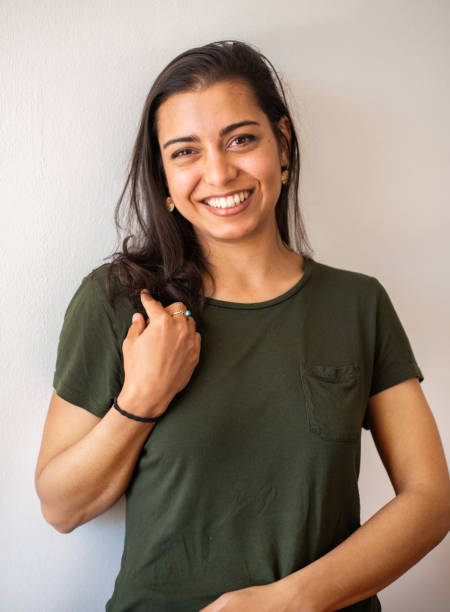 istock Young brunette woman leaning back against a wall and laughing 1349343002