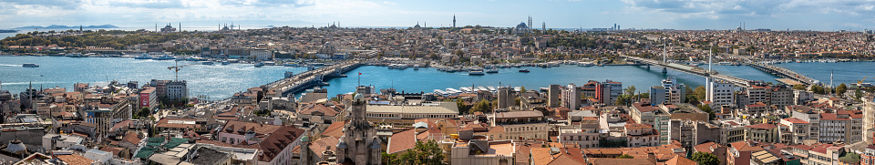 Istanbul, Turkey - october 12 ,2021: Istanbul city view from Galata tower in Turkey. Golden Horn bay of Istanbul and view on mosque with Sultanahmet district against blue sky and clouds.