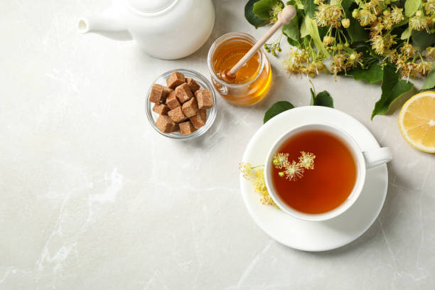 istock Flat lay composition with tasty tea and linden blossom on light grey marble table. Space for text 1349348137