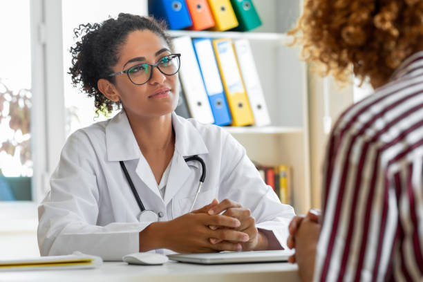 female patient speaking with her paediatrician in a doctors office - drug awareness imagens e fotografias de stock