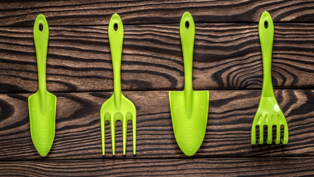 istock Gardening tools concept. Spade and fork on wooden background with space for text flat lay top view. 1349350551