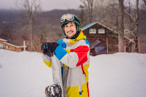 Male snowboarder at a ski resort in winter.