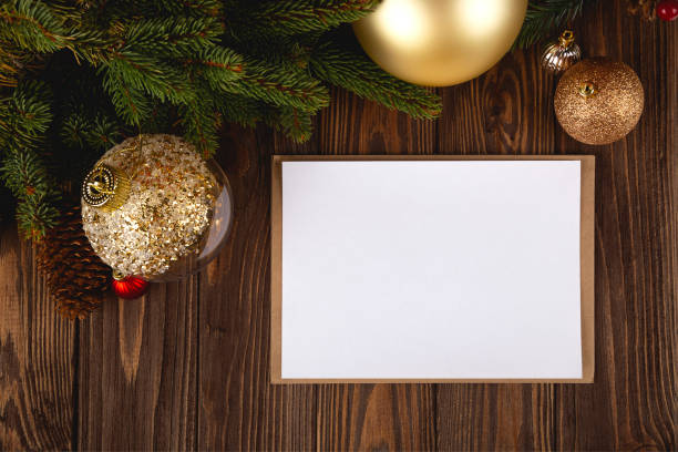 istock Christmas card mockup. White minimal empty postcard on wooden table with festive decorations and craft envelope. 1349352927