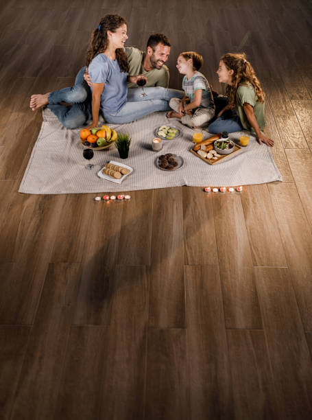 Happy family talking while having a picnic on parquet floor.