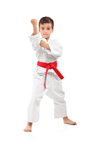 Full length portrait of a karate kid posing isolated on white background