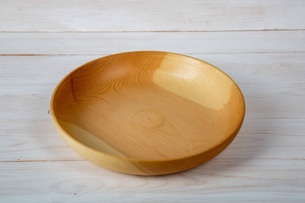 istock Handmade wooden tableware with a glossy lacquered surface on a white board background. Tableware made of precious wood. concept is environmentally friendly products. 1349354415