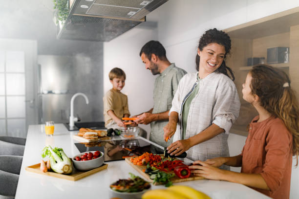 istock Happy family talking while preparing a meal in the kitchen. 1349355229