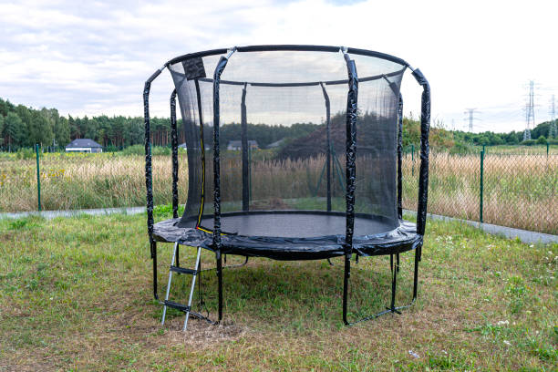 istock Large childrens jumping trampoline with protective net and closed zipper, standing in the garden. 1349359996