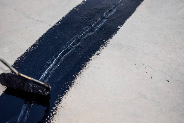 istock a painter is putting ceiling joint coating black paint on the rooftop 1349360070
