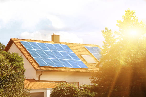 Solar panels on the tiled roof of the building in the sun. Solar panels on the tiled roof of the building in the sun. Electricity production for own needs and for sale energy efficient houses