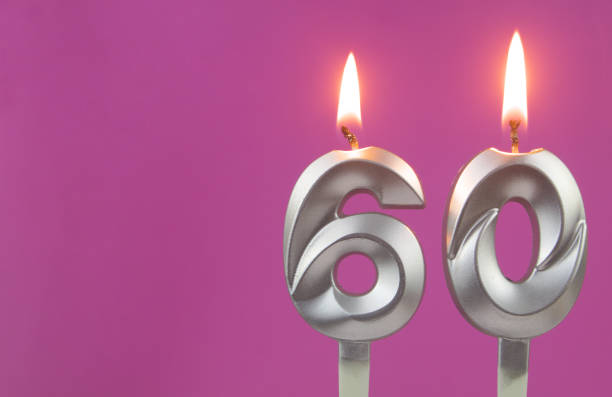 istock Silver birthday candles on pink background with room for text, number 60 1349363106