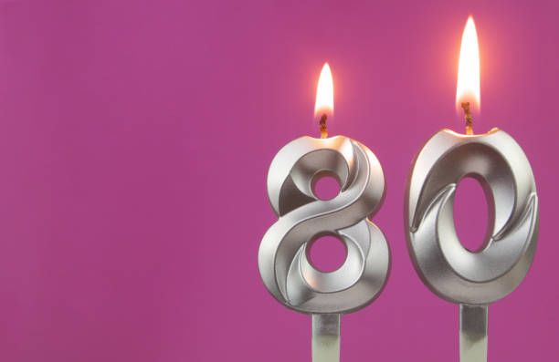 istock Silver birthday candles on pink background with room for text, number 80 1349363138