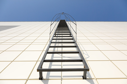Stick figure climbing ladder to success