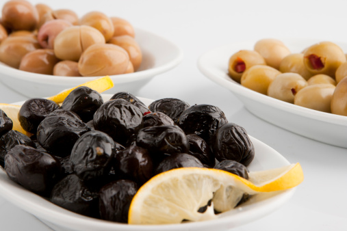 a plate of olives on a white background.