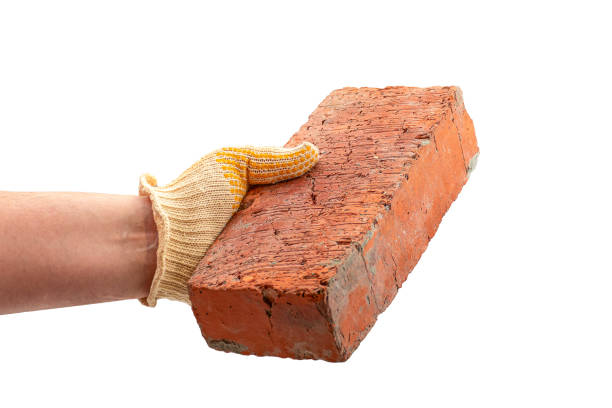 close up brown brick in builder worker hand holding for building work in construction site. construction and industry concept