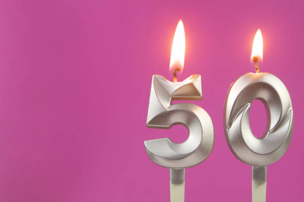 istock Silver birthday candles on pink background with room for text, number 50 1349372030
