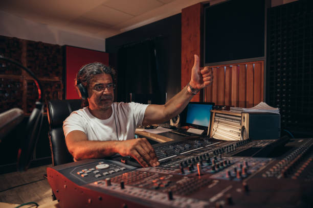 istock Senior hispanic music producer working on a mixing soundboard while in his studio 1349372534